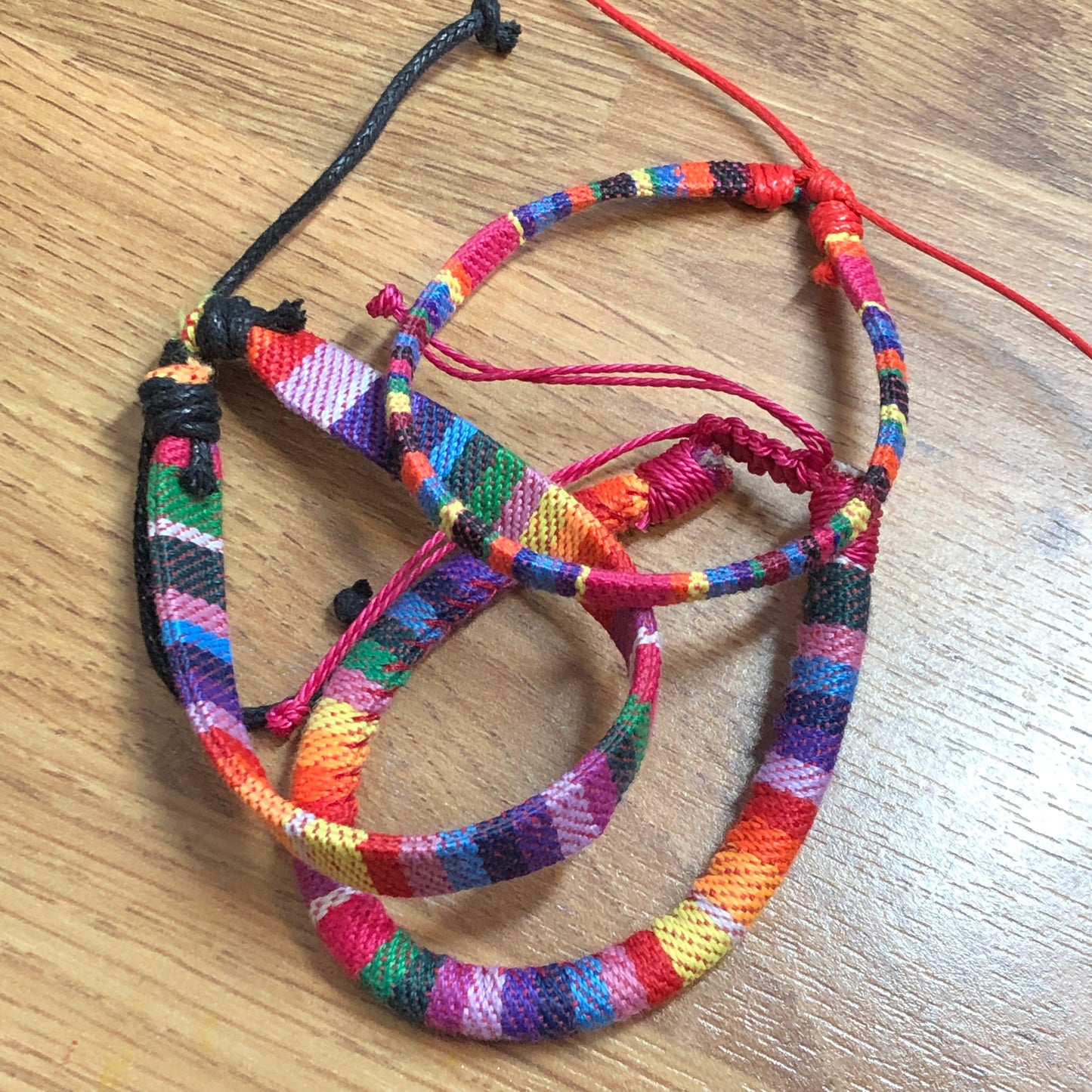 Three rainbow handmade string cord braided woven stackable bracelets