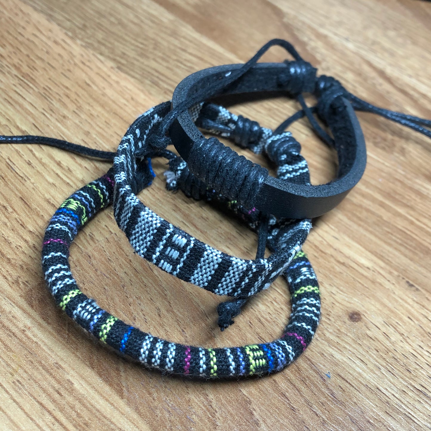 Three monochrome handmade Bohemian cord braided woven stackable bracelets