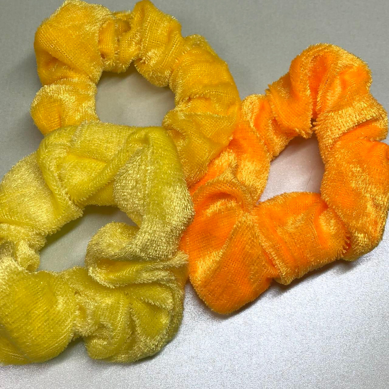 Three yellow velvet hair scrunchies