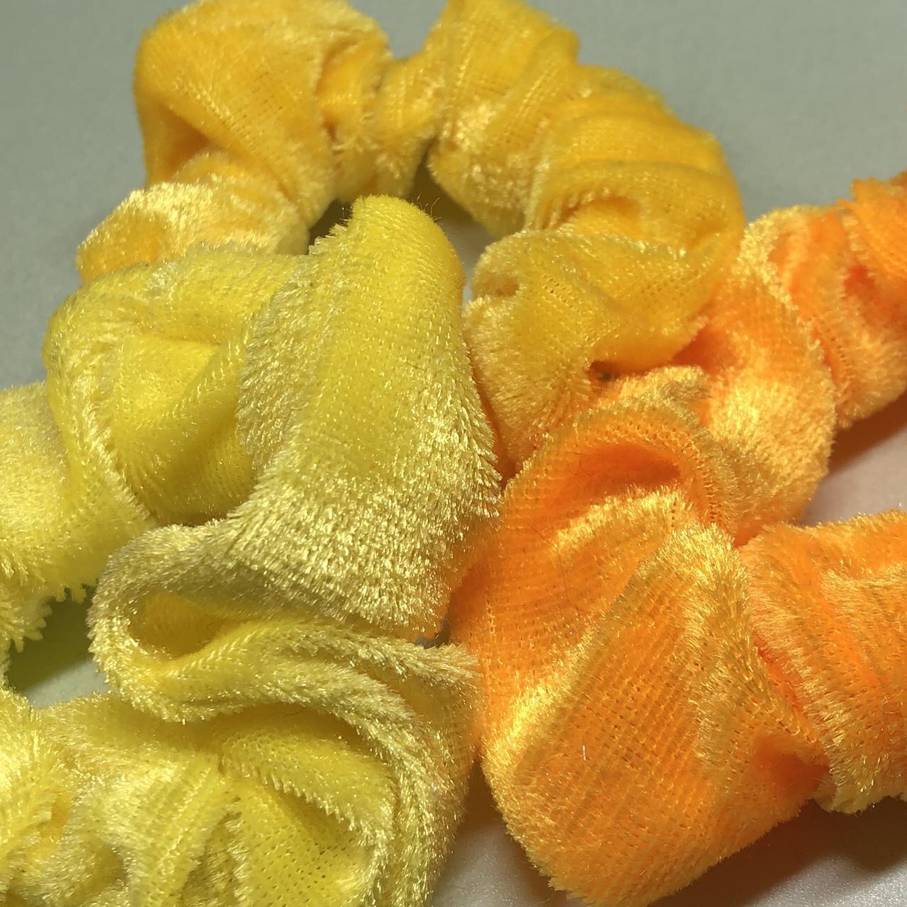 Three yellow velvet hair scrunchies