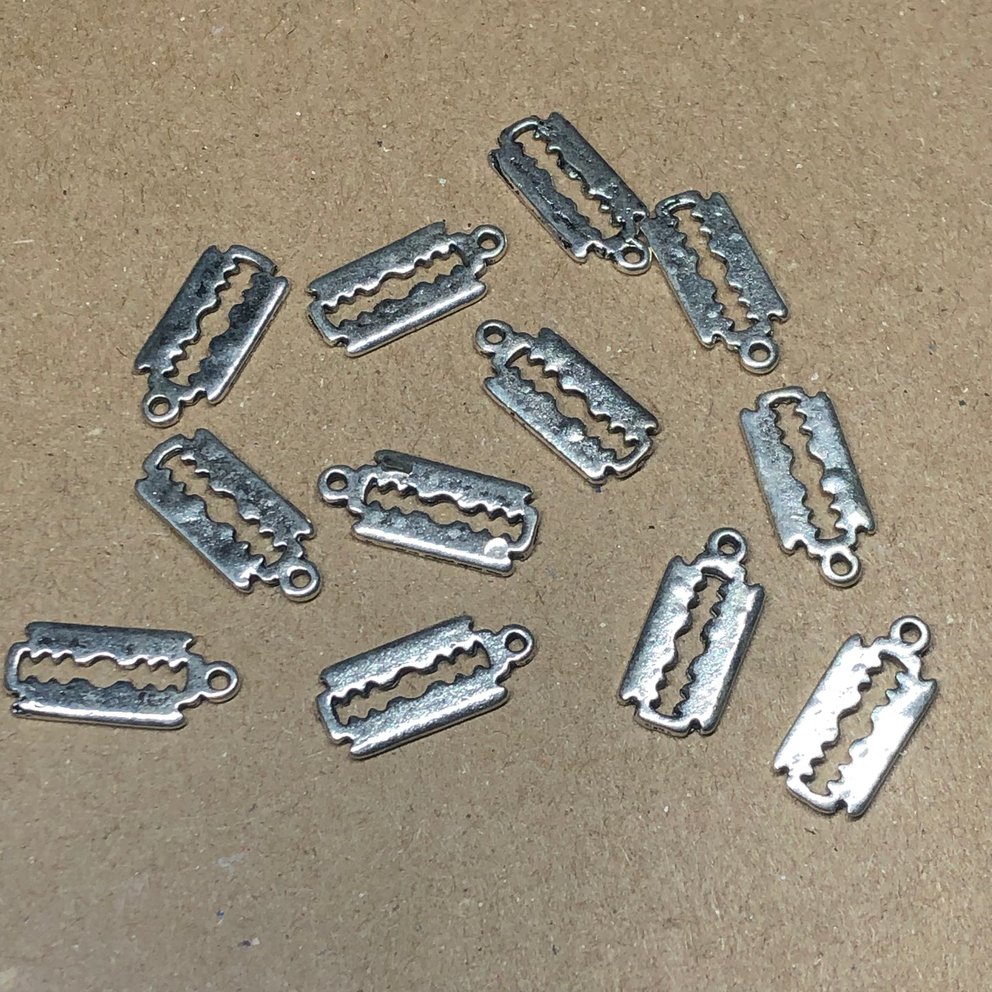 Twelve razor blade charms