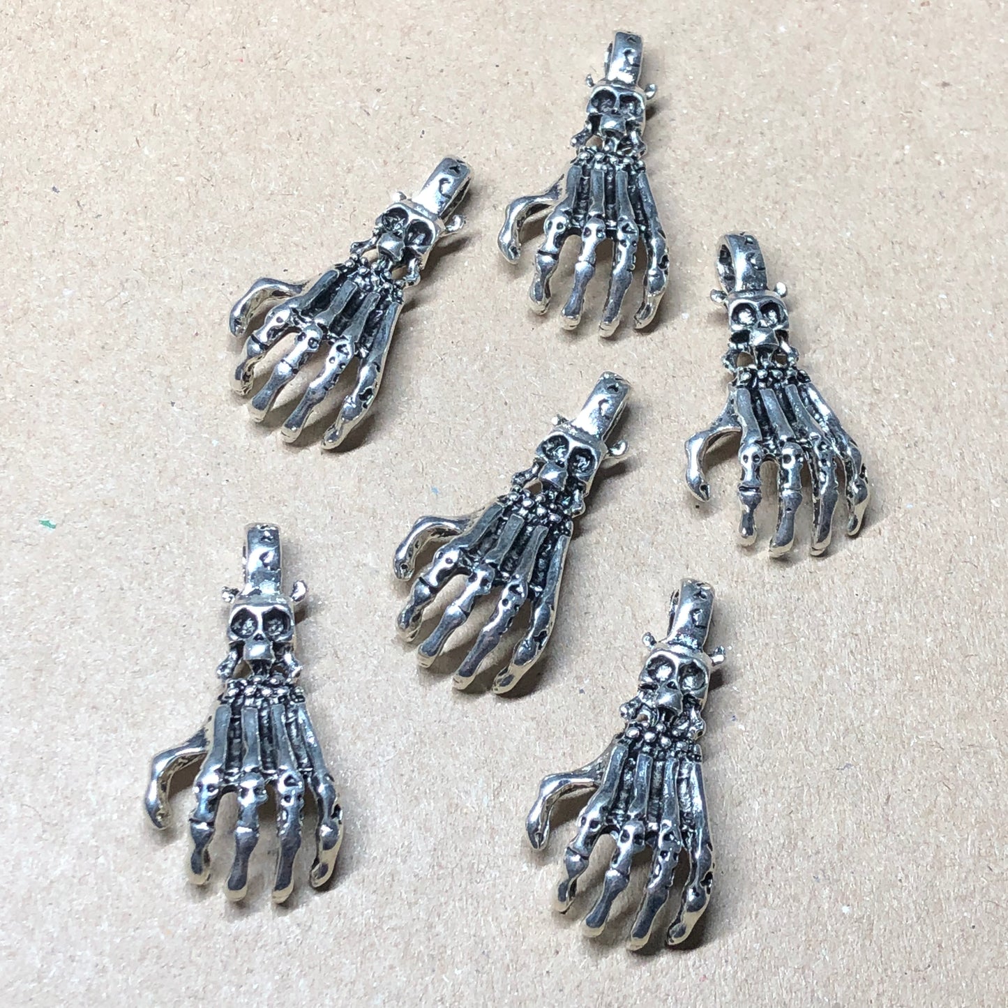 Six large skeletal hand charms