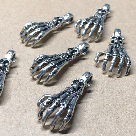 Six large skeletal hand charms