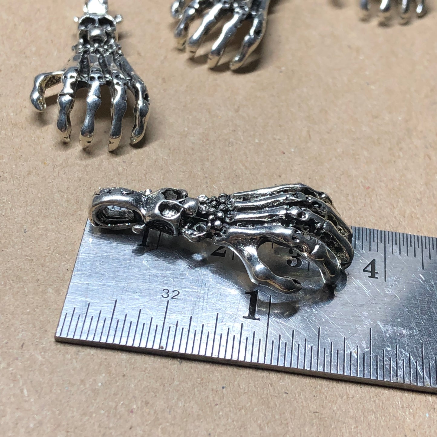 Six large skeletal hand charms