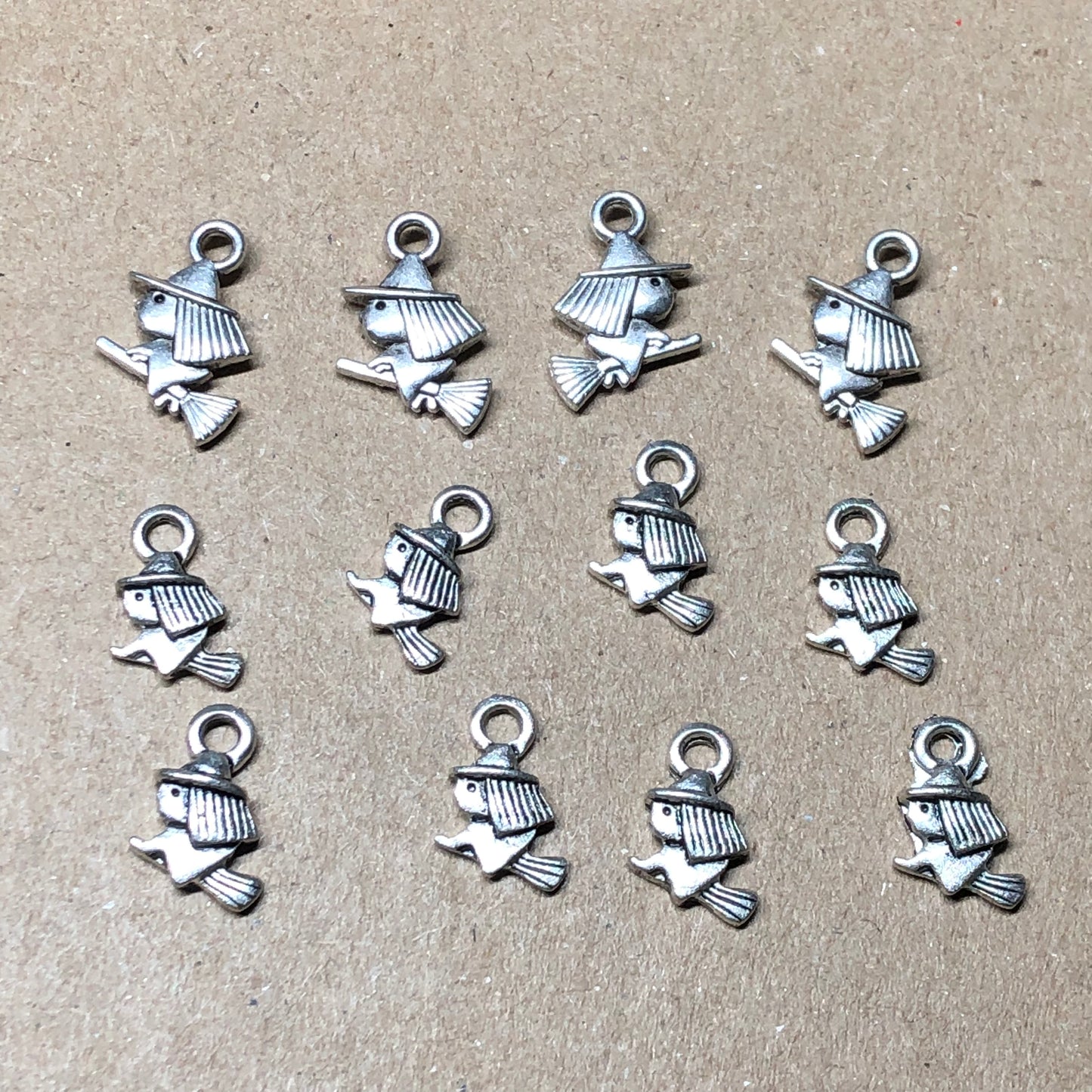 Twelve small witch on broomstick charms