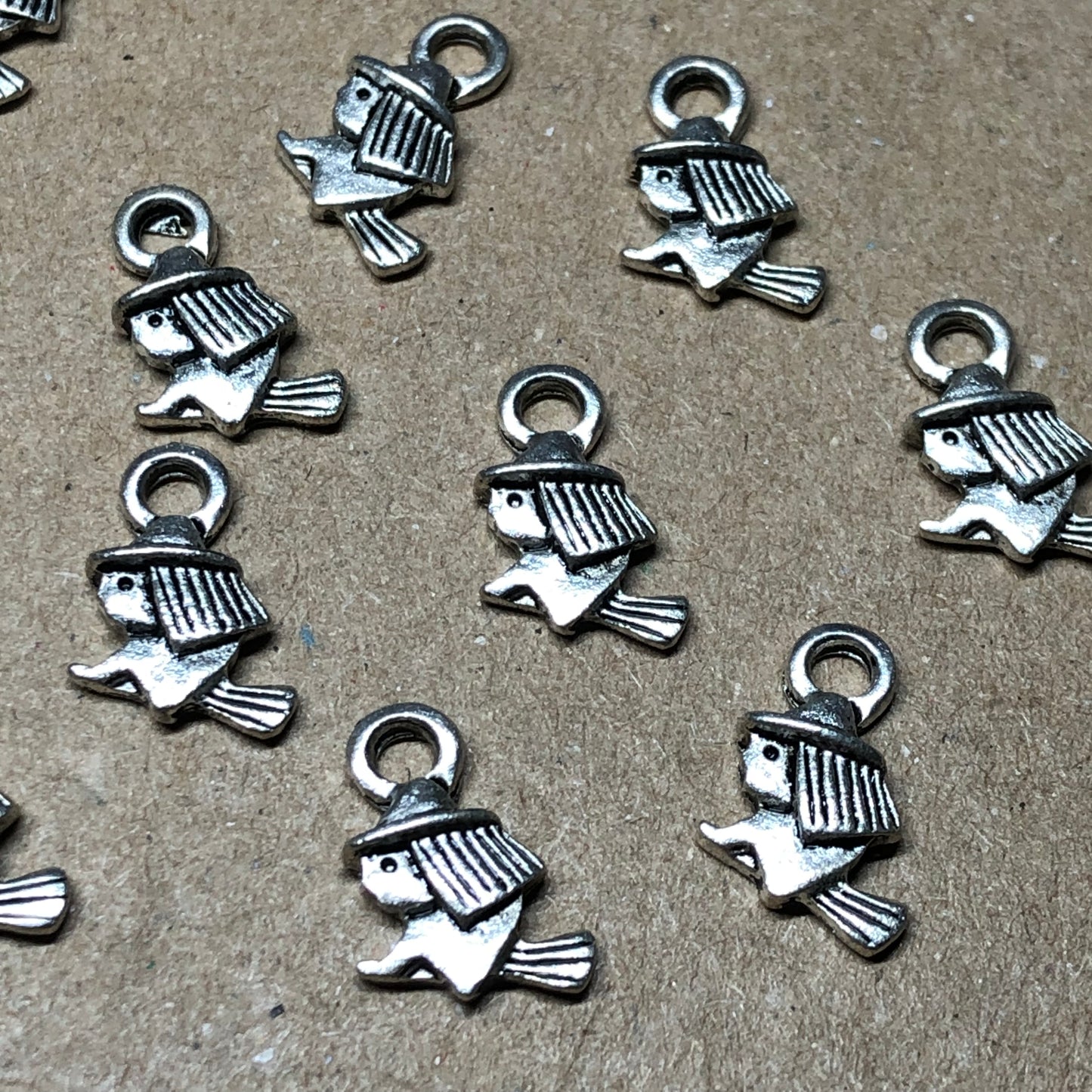 Twelve tiny witch on broomstick charms