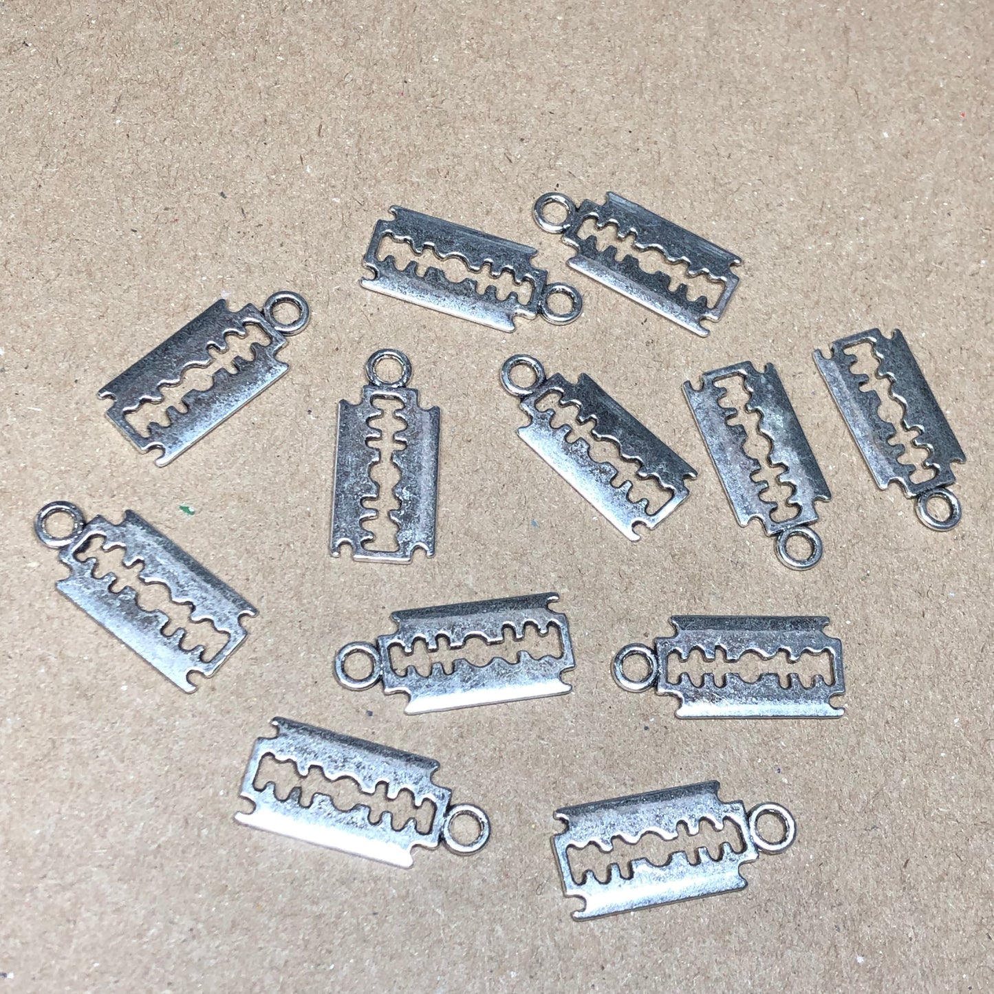 Twelve large razor blade charms