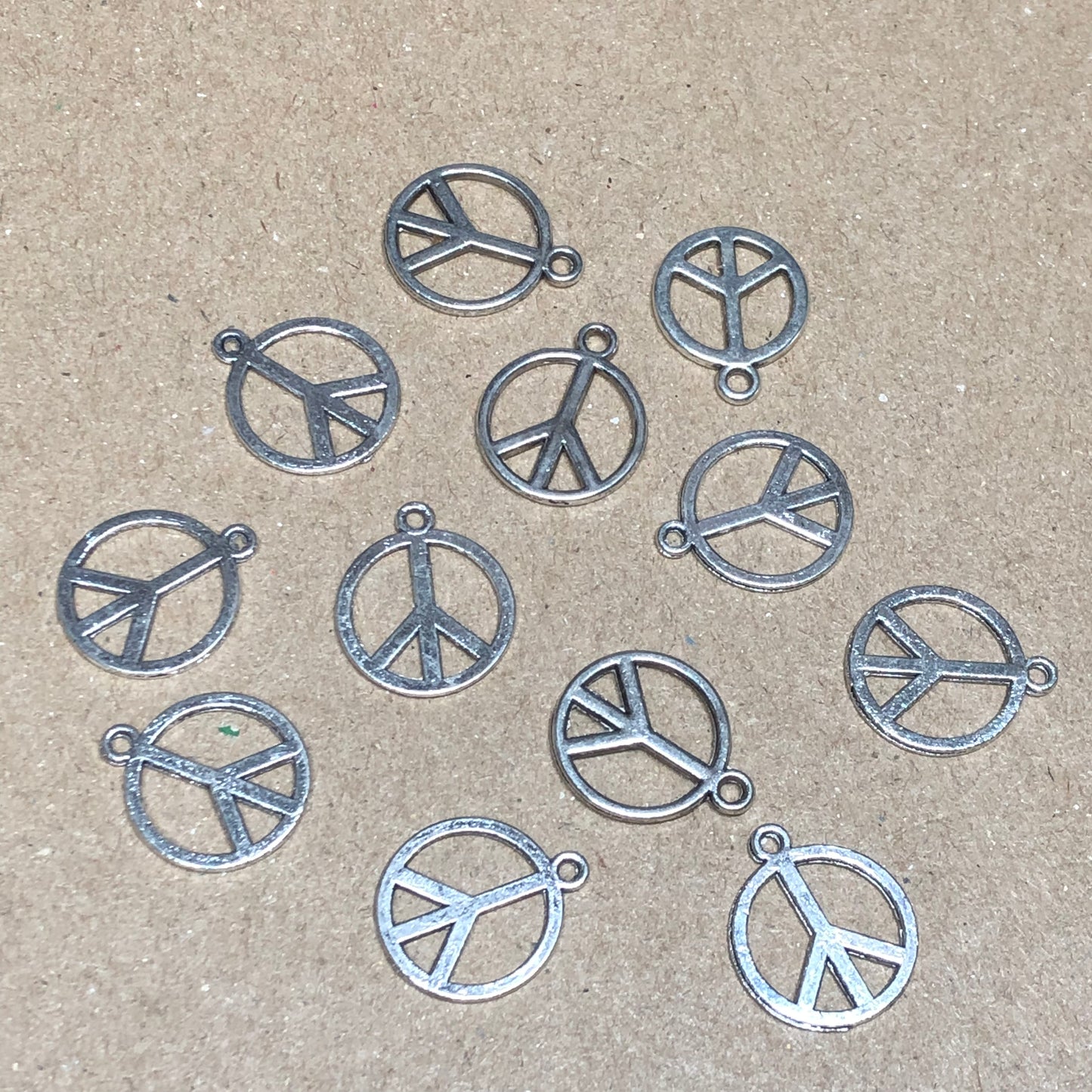 Twelve peace symbol charms