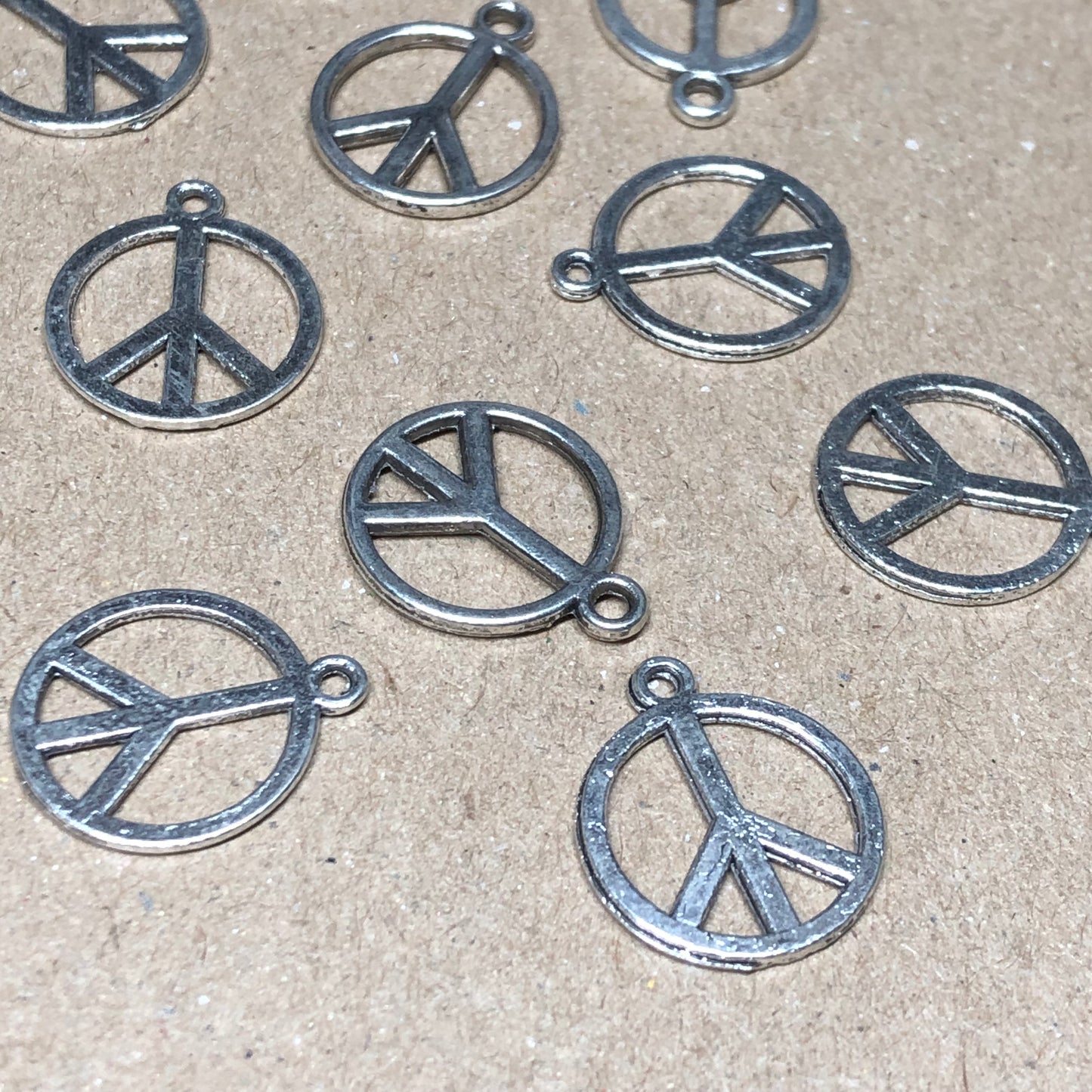 Twelve peace symbol charms