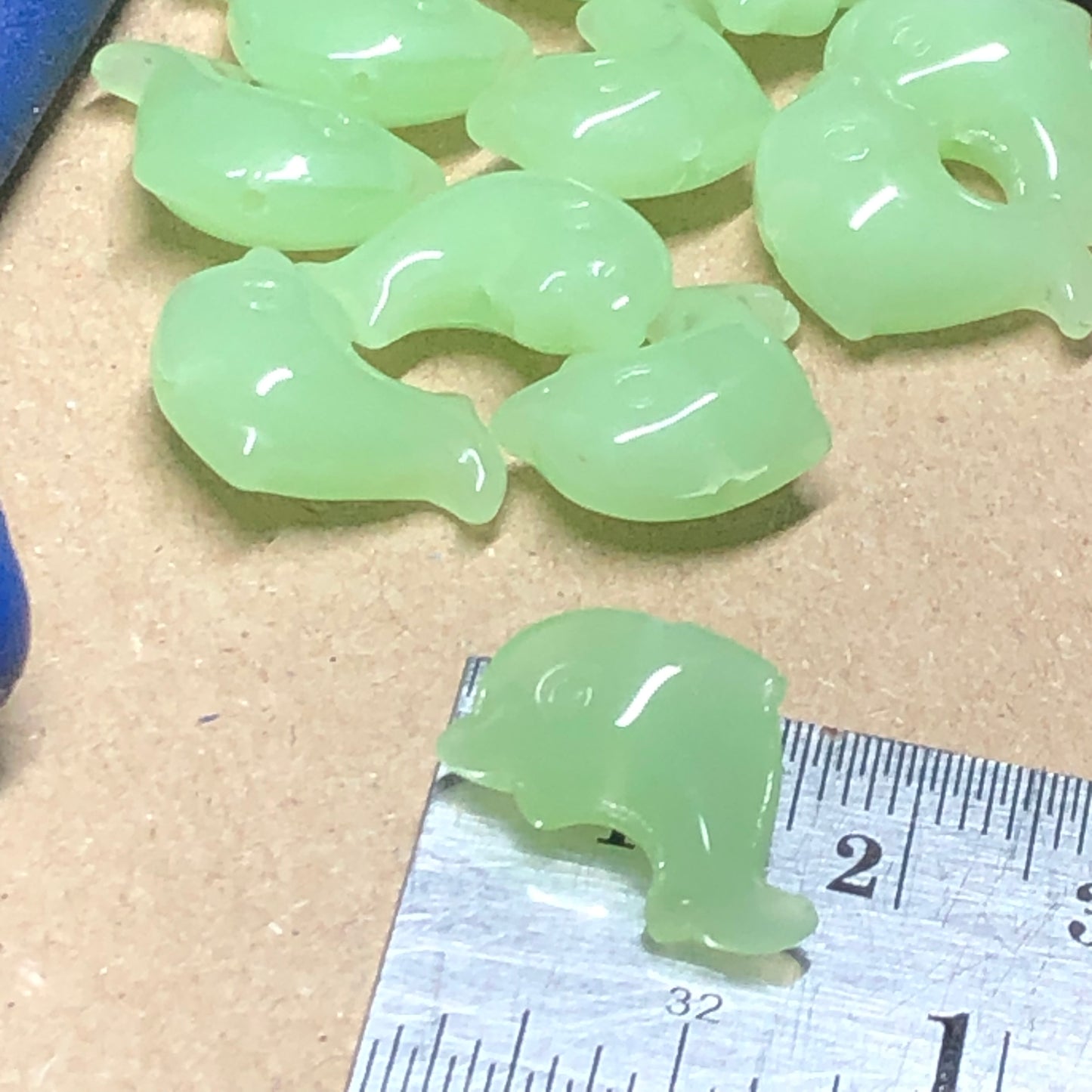 Green opaque dolphin shaped glass beads