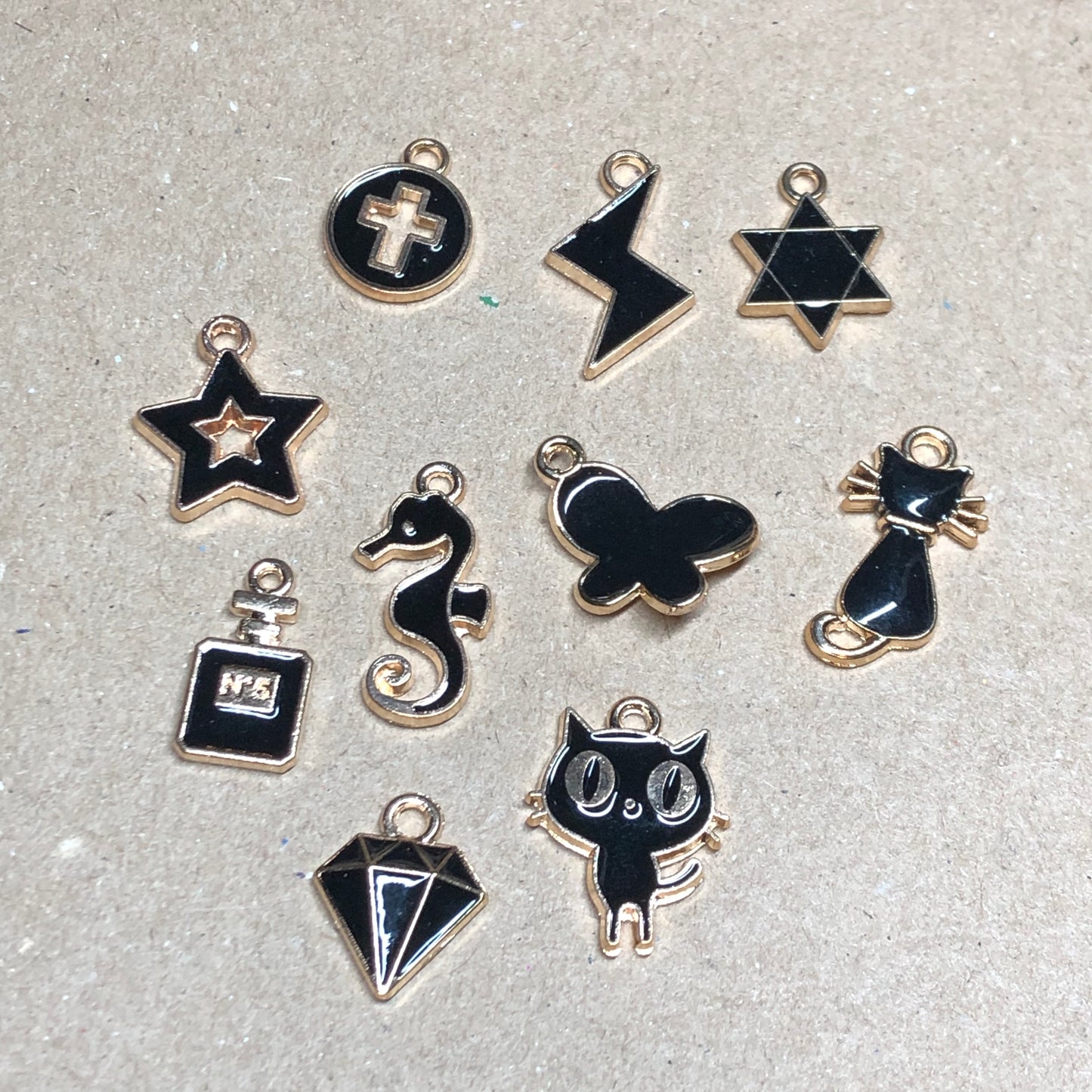 Ten gold and black enamel charms