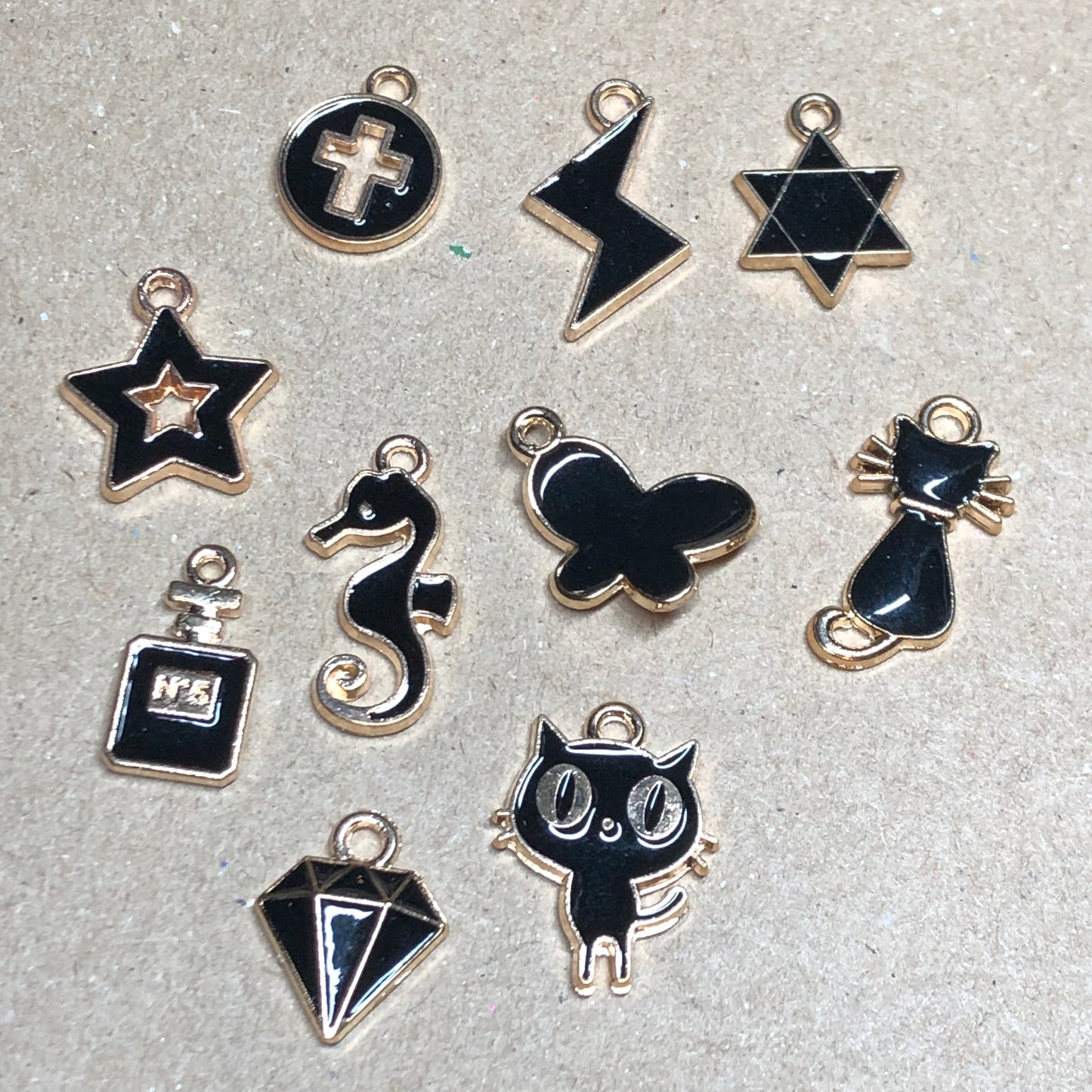 Ten gold and black enamel charms