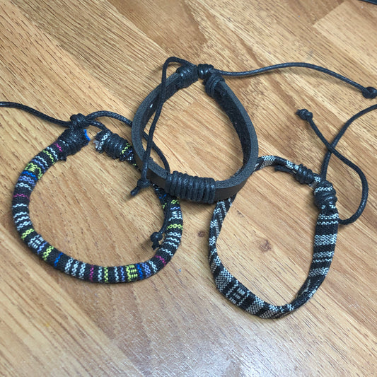 Three monochrome handmade Bohemian cord braided woven stackable bracelets