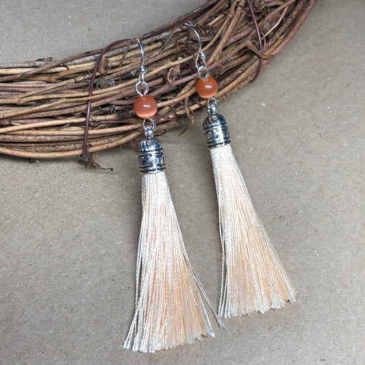 Peach tassel earrings with cats eye glass