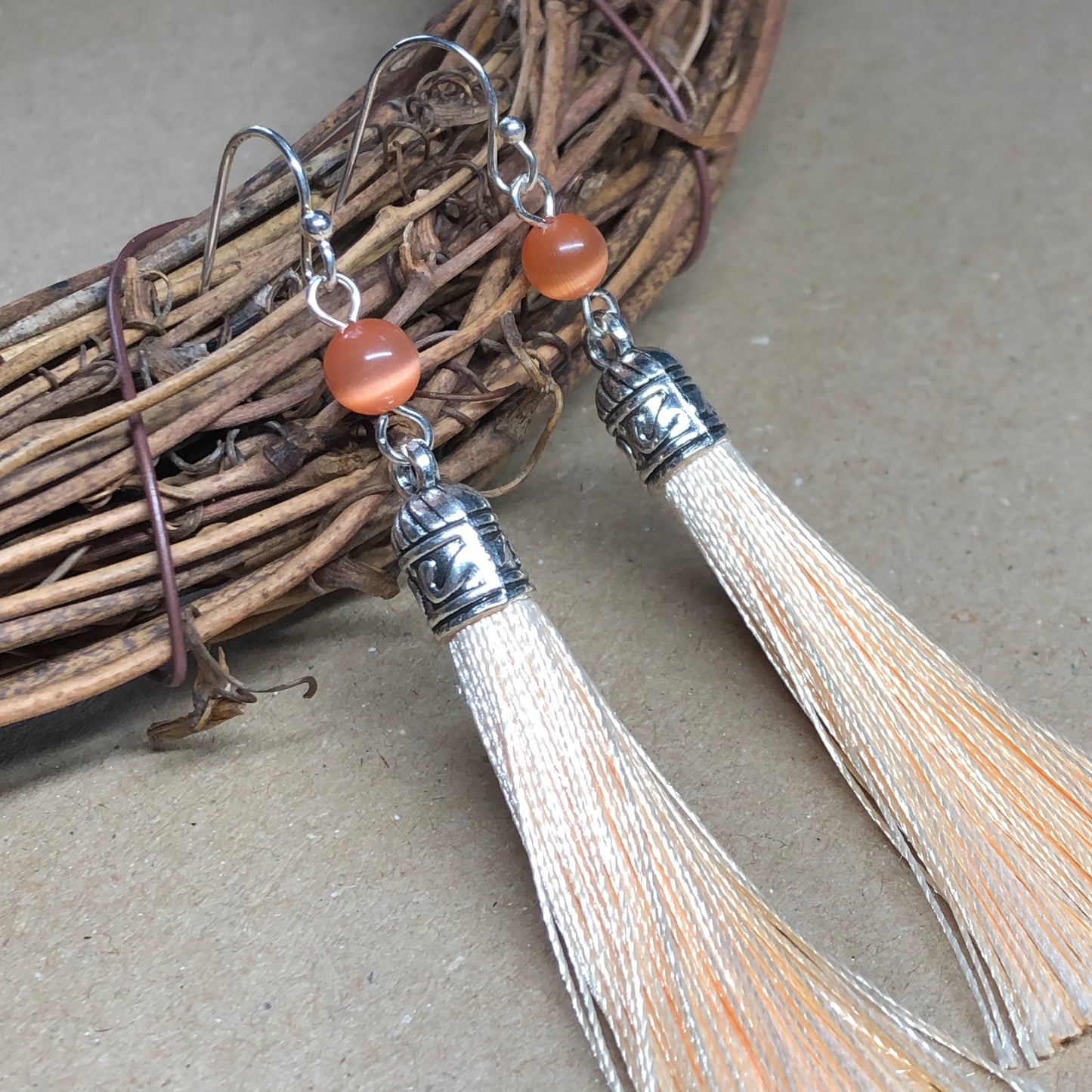 Peach tassel earrings with cats eye glass