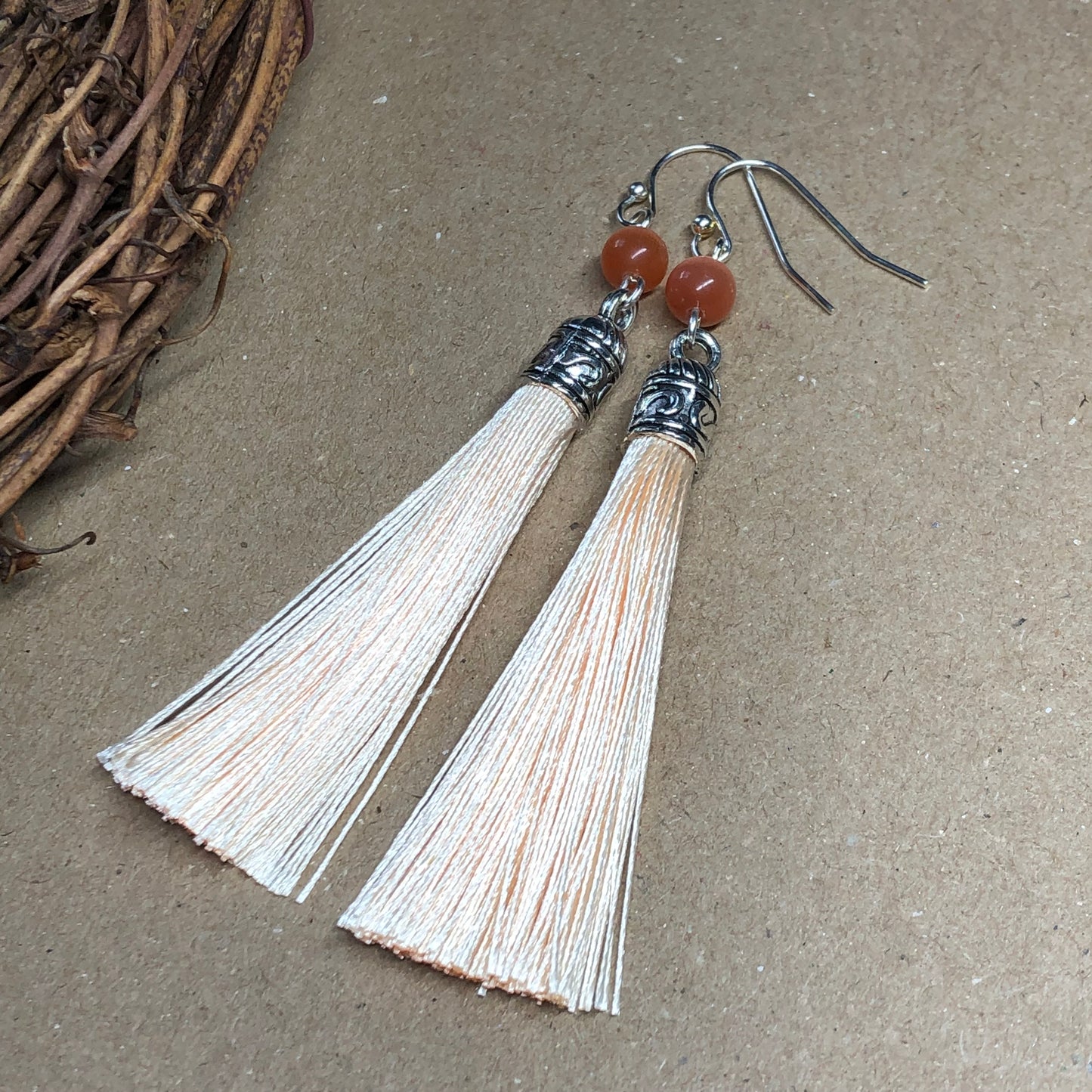 Peach tassel earrings with cats eye glass