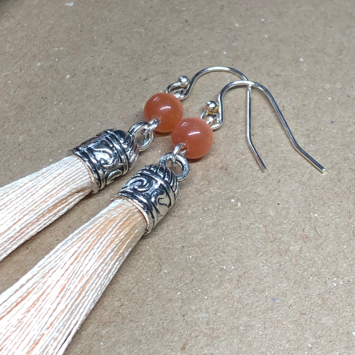 Peach tassel earrings with cats eye glass