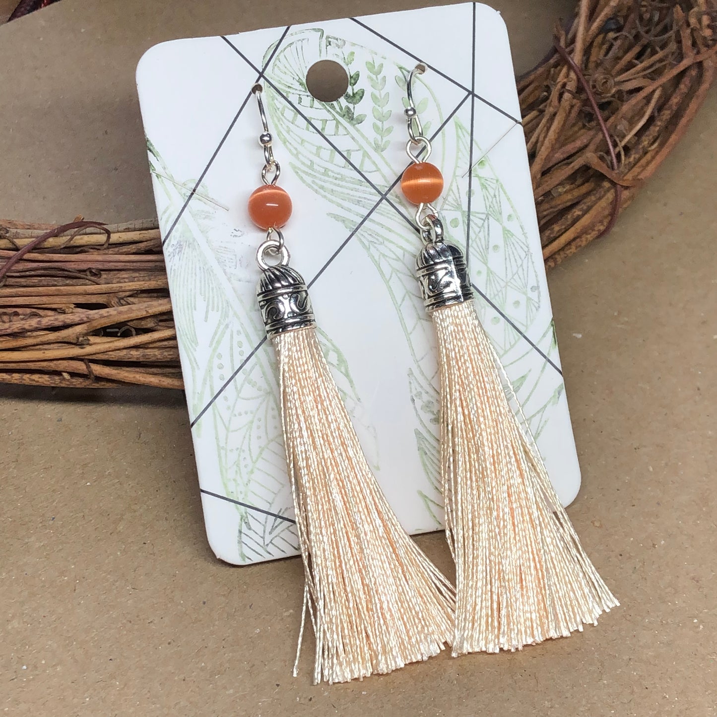 Peach tassel earrings with cats eye glass