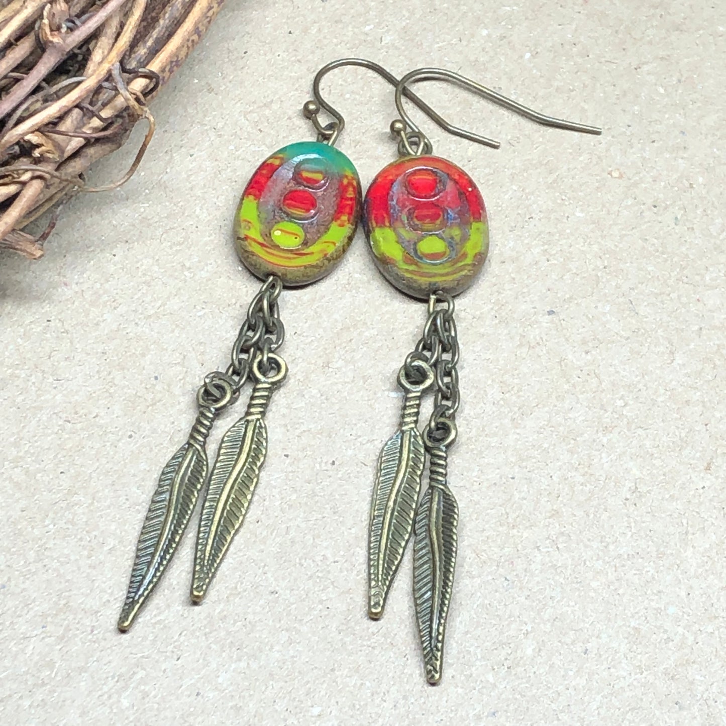 Feather charm earrings with red and green glass beads