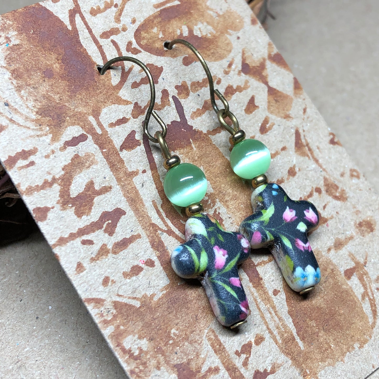 Green cats eye floral cross earrings